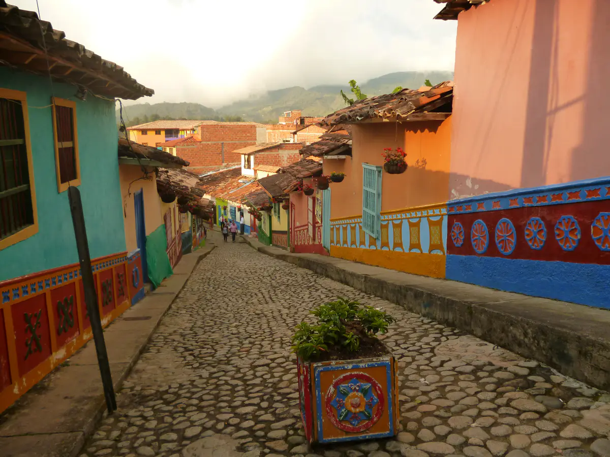 Calle empedrada de Guatapé con casas de colores y zócalos en relieve.