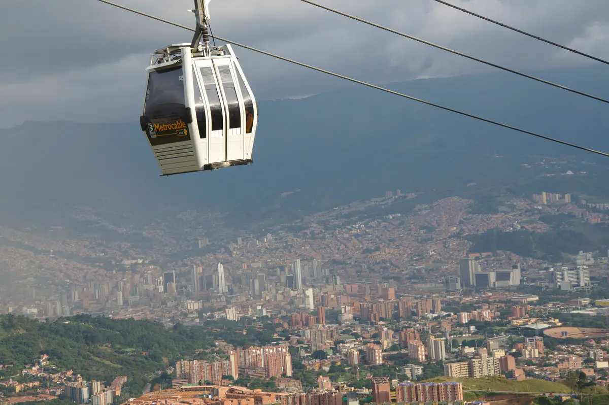 Una cabina del Metrocable suspendida sobre Medellín, con la ciudad extendida en el valle.