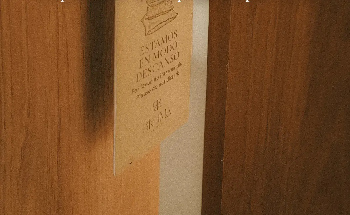 Aviso colgado en la manija de una puerta de madera: «Estamos en modo descanso. Por favor, no interrumpir».